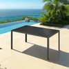A rectangular outdoor table is placed on a tiled patio next to a swimming pool with a view of the ocean. Voir les images du produit