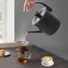 A hand is pouring hot water from a black electric kettle into a pour-over coffee maker, with a cup of coffee and pastries in the foreground. Podgląd zdjęcia produktu