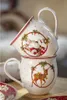 Two ceramic mugs with Christmas-themed designs are stacked on top of each other. Produktbild-Vorschau