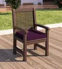 A brown outdoor chair with a purple cushion sits on a wooden deck, with grass and a building in the background. Produktbild-Vorschau