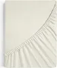 A close-up view of a cream-colored fitted sheet, showing the elasticized edge. Produktbild-Vorschau