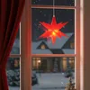 A red star-shaped LED light hangs in a window on a snowy night, with a red curtain to the left. Produktbild-Vorschau
