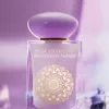 A close-up studio shot of a perfume bottle with a purple cap and a frosted glass body, featuring a gold mandala design and text. Anteprima dell’immagine prodotto
