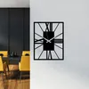 A modern dining room with yellow chairs around a black table, and a black metal wall clock on a white wall. Podgląd zdjęcia produktu