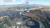 An aerial view of a seaplane flying over a residential area with canals and boats. Produktbild-Vorschau