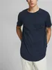 A man wearing a navy blue t-shirt and light-colored pants. Produktbild-Vorschau