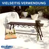 A metal garden bench with decorative ornaments and a cushion with a landscape print, placed on a white patio with potted plants in the background. Anteprima dell’immagine prodotto