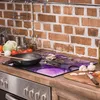 A kitchen counter with a stove, cooking ingredients, and a glass stove top cover. Náhled obrázku produktu