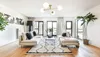 A modern living room with a sofa, coffee table, rug, and a ceiling lamp. Produktbild-Vorschau