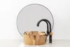 A modern bathroom sink and faucet set against a plain white background with a large circular mirror behind it. Produktbild-Vorschau