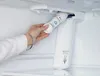 A person is installing a water filter into a refrigerator. Náhled obrázku produktu