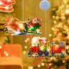Christmas-themed window decorations featuring a Santa sleigh with reindeer and a Santa train, illuminated with LED lights, hanging in front of a blurred Christmas tree and interior. Náhled obrázku produktu