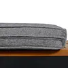 A close-up view of a gray cushion on a wooden and black base. Podgląd zdjęcia produktu
