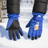 Hands wearing blue winter gloves in the snow. Produktbild-Vorschau
