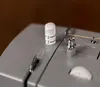 A close-up view of a sewing machine's tension dial and bobbin winder. Náhled obrázku produktu