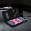 A black flip cover case for an iPhone 11 is shown open, with the phone inside, resting on a dark gray textured surface. The background is dark and out of focus, suggesting an indoor setting. Anteprima dell’immagine prodotto