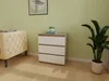 A dresser with three drawers is placed in a room next to a sofa and a plant. Náhled obrázku produktu