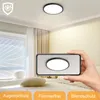 A bedroom scene with a ceiling light and a hand holding a smartphone showing the ceiling light. Voir les images du produit