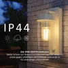An outdoor wall light is shown mounted on a brick wall during a rain shower. Produktbild-Vorschau