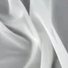 A close-up view of white fabric draped and folded. Produktbild-Vorschau