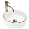 A white ceramic sink with a gold rim and a gold faucet. Produktbild-Vorschau