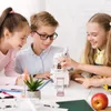 Three children are gathered around a table, looking at a robotic arm model and a pink hourglass. Voir les images du produit