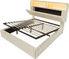 A beige upholstered bed frame with a slatted mattress base lifted to reveal storage space underneath. The headboard features integrated LED lighting. Náhled obrázku produktu