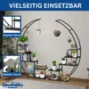 A black metal plant stand with multiple shelves, shaped like a crescent moon, displaying various potted plants, books, and decorative items. The stand is placed indoors on a wooden floor with a rug. Anteprima dell’immagine prodotto