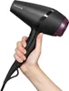 A hand holding a black hairdryer with purple accents. Náhled obrázku produktu