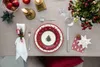 A Christmas-themed table setting with plates, cutlery, and decorations. Voir les images du produit