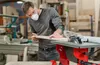 A man is using a table saw in a workshop. Náhľad obrázku produktu