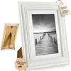 A white vintage-style picture frame with a black and white photo of a pier on a lake. Anteprima dell’immagine prodotto