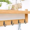 A wooden shelf with hooks attached to the underside. A plant and jars are on the shelf. Podgląd zdjęcia produktu