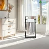 A bedroom or living room setting with a dresser and a towel rack. Produktbild-Vorschau