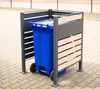 A blue trash bin inside a modern metal and wood enclosure on a paved surface. Náhled obrázku produktu