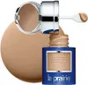 A bottle of La Prairie Skin Caviar Concealer Foundation SPF 15 is shown with its lid open and applicator extended, with a large swatch of foundation behind it. Produktbild-Vorschau