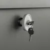 A close-up shot of a key in a lock on a gray surface. Produktbild-Vorschau