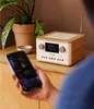 A person is holding a smartphone in front of a Pure Classic C-D4 radio. Voir les images du produit