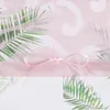 A close-up of a pink sheer curtain with a palm leaf pattern and a pink ribbon tied in a bow. Produktbild-Vorschau