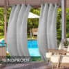 Outdoor curtains hanging on a patio overlooking a swimming pool and lounge area.