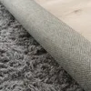 Close-up view of the underside and pile of a shaggy rug. Voir les images du produit