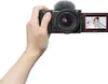 A hand holds a Sony camera, showing its screen displaying a person. Produktbild-Vorschau