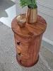 A wooden side table with three drawers, topped with a decorative acorn and a vase with a plant. Podgląd zdjęcia produktu