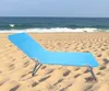 A blue beach chair on a sandy beach with the ocean in the background. Produktbild-Vorschau