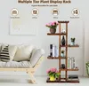 A wooden plant stand is shown in a living room setting next to a sofa, with various plants and books displayed on its shelves. Produktbild-Vorschau