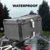 A black motorcycle top case is shown in the rain, with trees in the background. The word "WATERPROOF" is displayed prominently at the top of the image. Produktbild-Vorschau