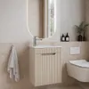 A modern bathroom vanity with a sink and cabinet, a wall-mounted toilet, and a mirror. Produktbild-Vorschau