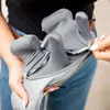 A person is holding a gray massage device, showing its internal structure. Produktbild-Vorschau