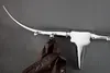 A silver coat rack shaped like a bull's head and horns, with a brown jacket hanging from one of the hooks, mounted on a gray wall. Produktbild-Vorschau