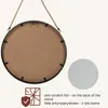 The back of a round mirror hanging by a rope, with a close-up of a textured surface and a graphic indicating anti-scratch foil. Produktbild-Vorschau